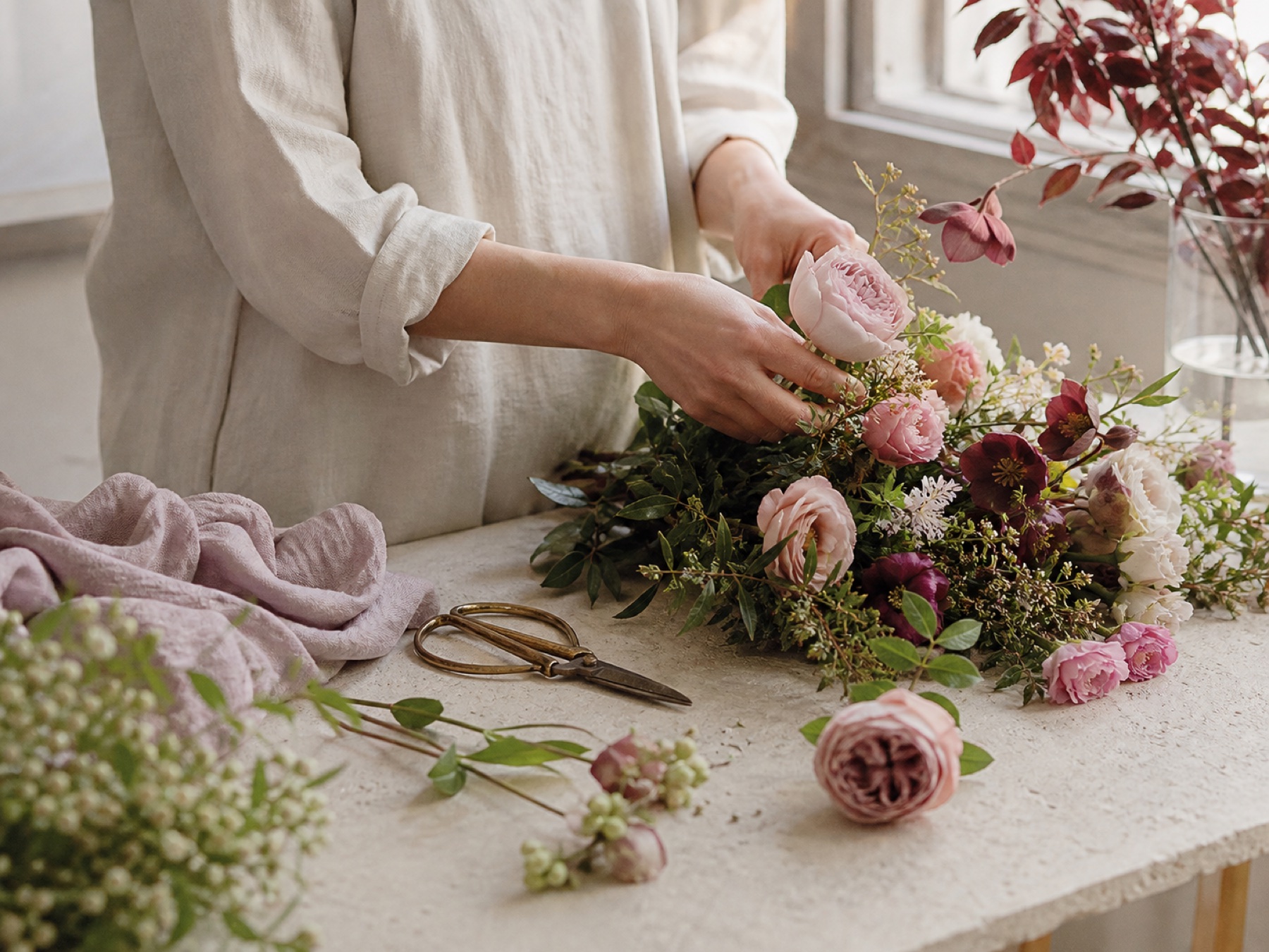 季節の花を組み合わせて制作する実技風景